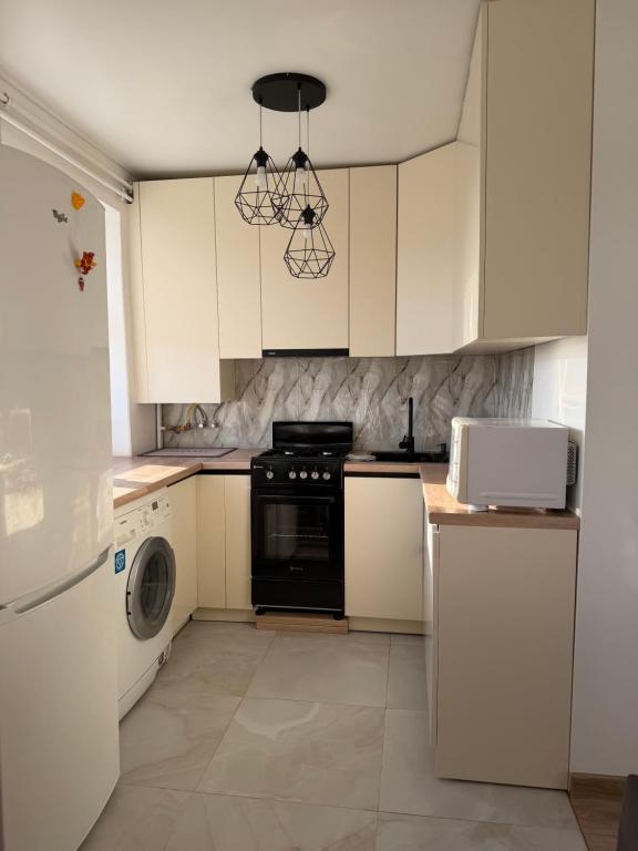 a kitchen with white cabinets and a black stove at Панорама in Borysxaw
