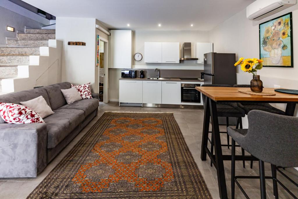 a living room and kitchen with a couch and a table at Cavour Living – Luxury Design Olbia Centro in Olbia