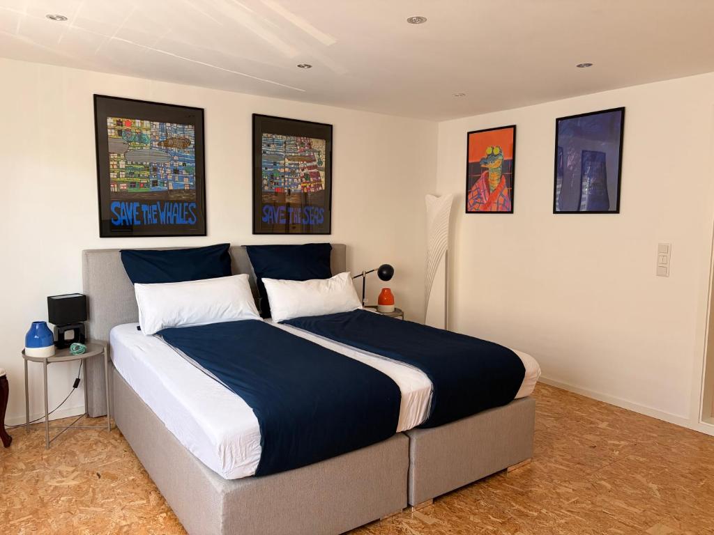 a bedroom with a large bed with blue and white sheets at Hermelsstübche in Siegen
