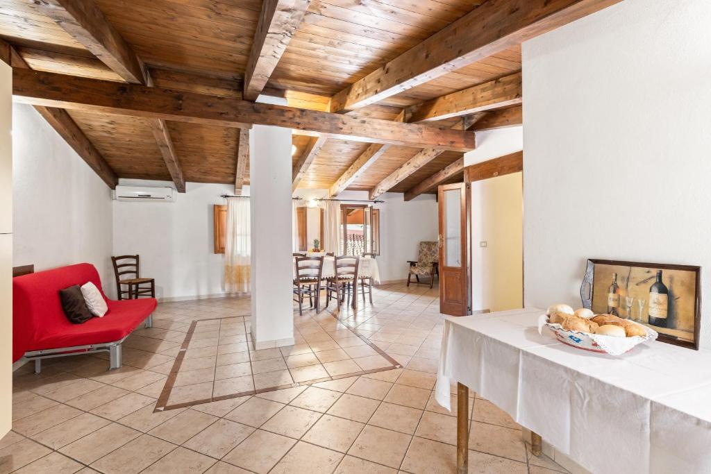 a living room with a red chair and a table at Grande Casa Nel Villaggio in Scano Montiferro