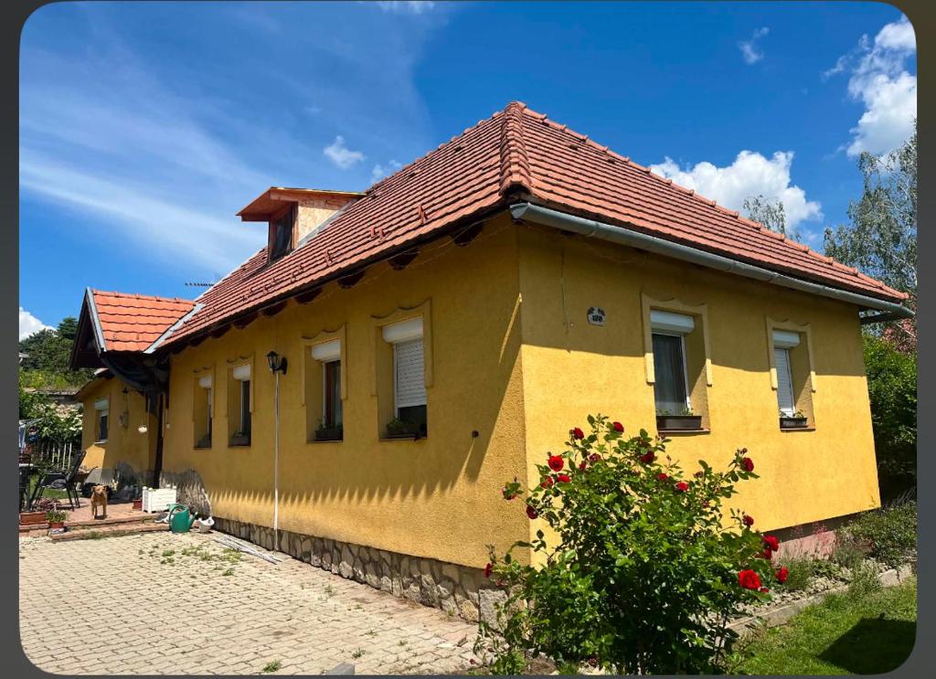 a yellow house with a red roof at BLTN House in Balatonalmádi