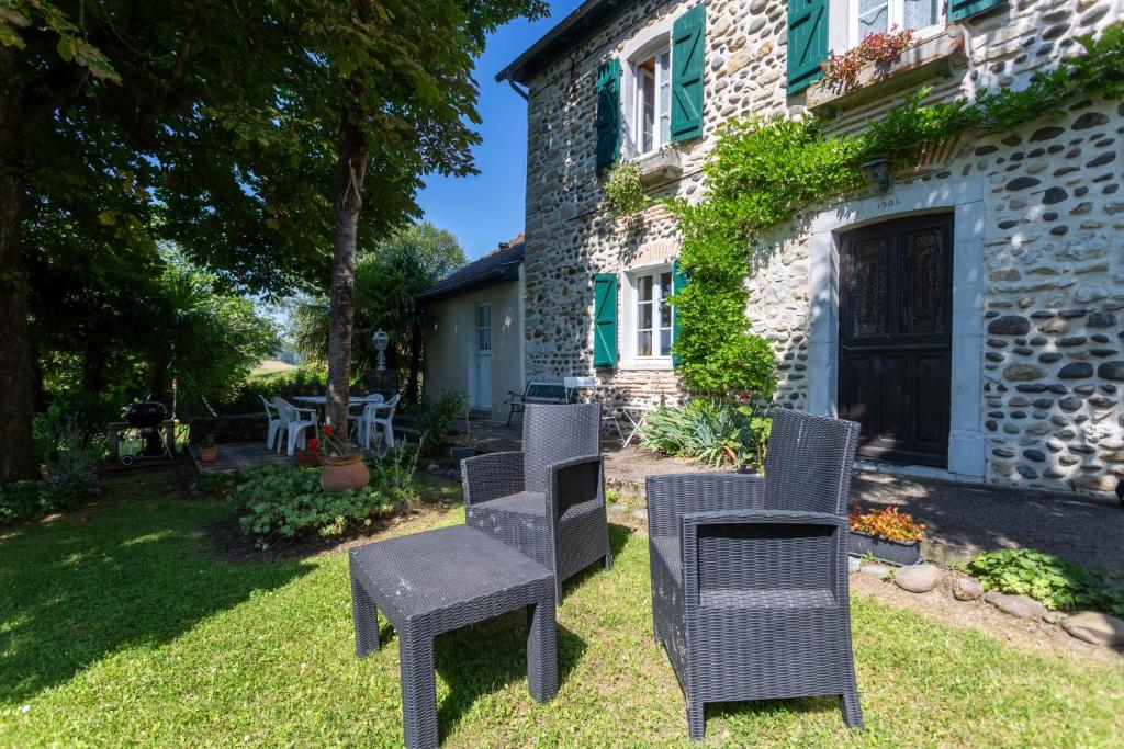 a group of chairs sitting in front of a building at L'Authentique Maison Béarnaise in Lagor
