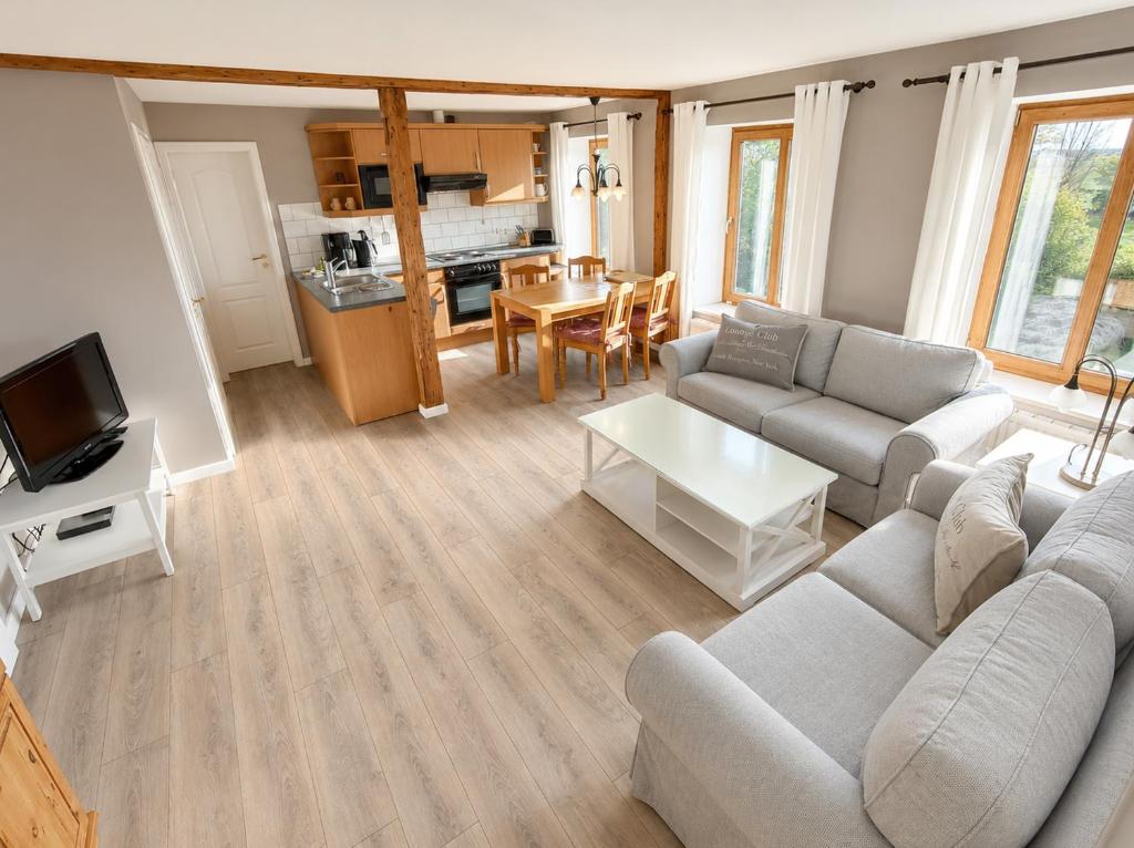 a living room with a couch and a table at Bauernhaus 3 -Vaest- in Fehmarn