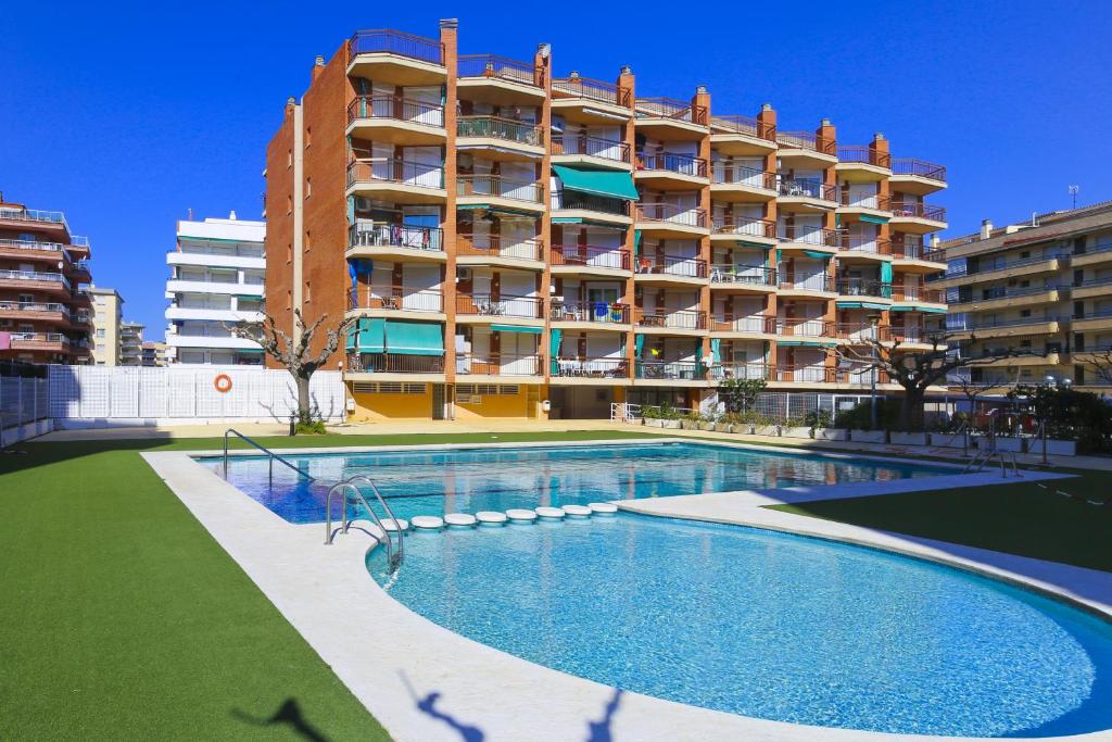 a large apartment building with a large swimming pool at TECAVI III Apartamento in La Pineda