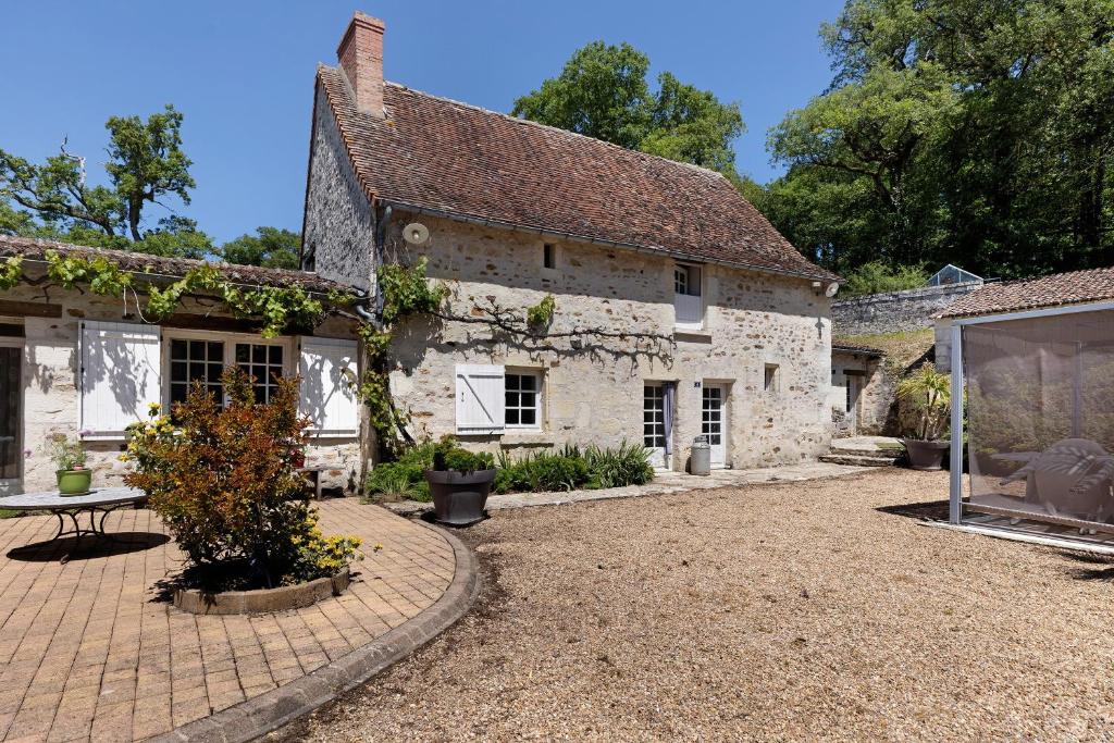 an old stone house with a patio in front of it at La Fromagerie in Mondion