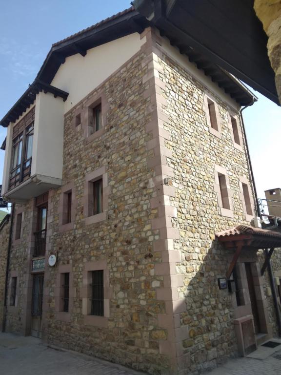 a large stone building with a black roof at Posada San Miguel in RIonansa