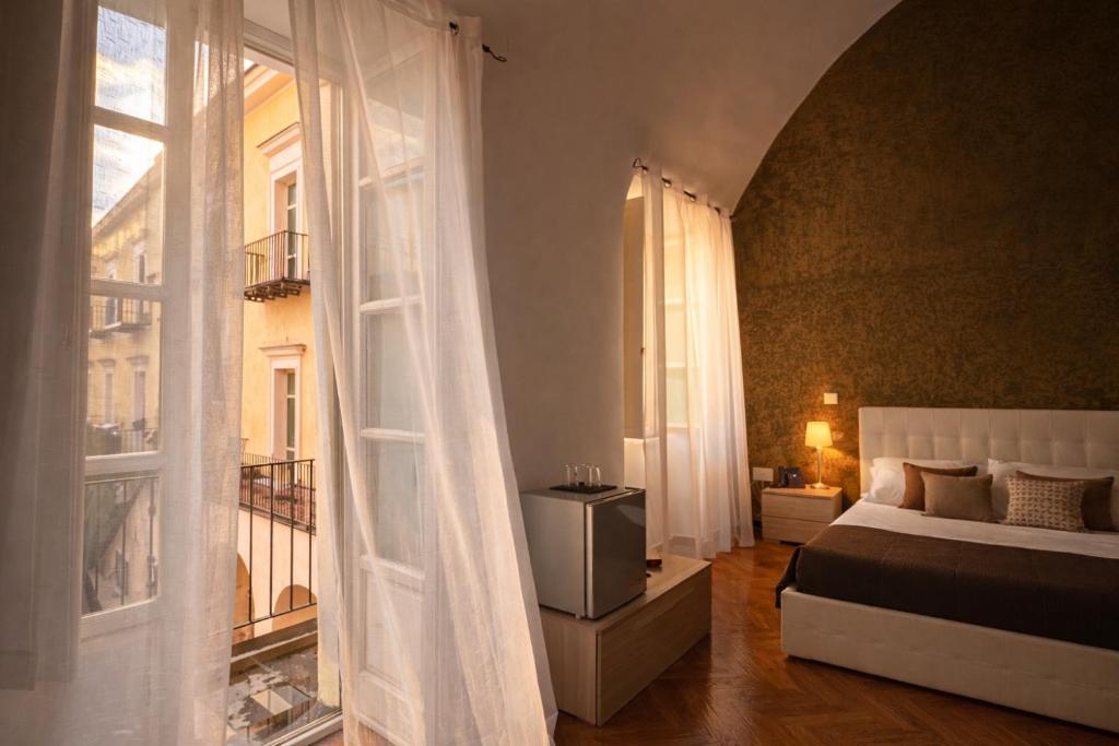 a bedroom with a bed and a large window at Hotel Terme Neronensis in Pozzuoli