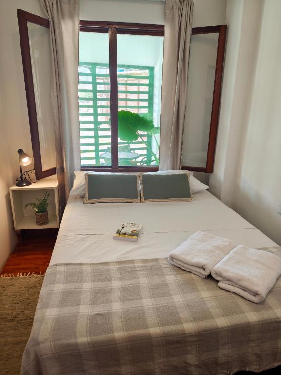 a bed in a room with a large window at La Casita de Kevin in Los Órganos