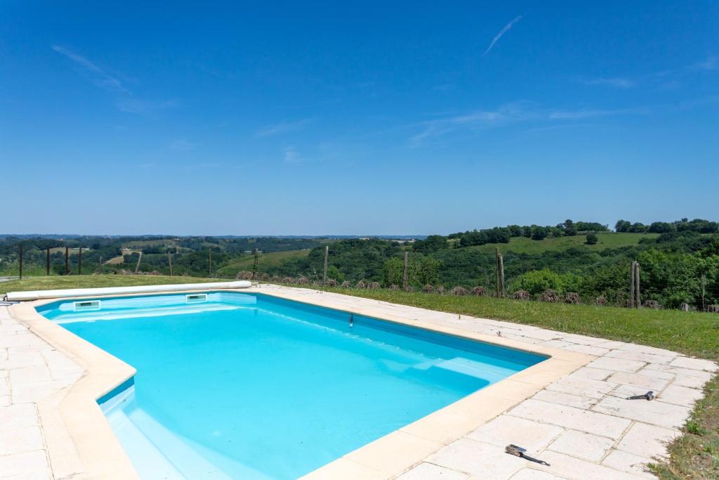 a swimming pool with blue water in a yard at Domaine Cherps Spa - Quietude in Vielleségure