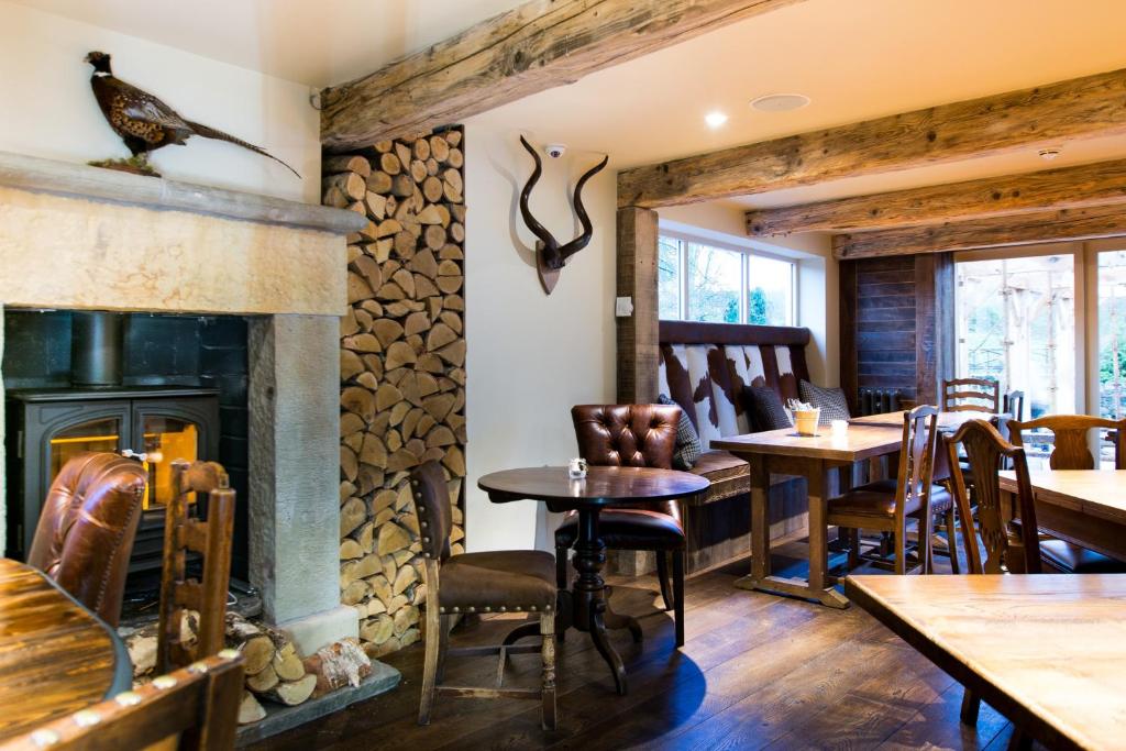 a fireplace in a restaurant with tables and chairs at Barley Mow in Burnley