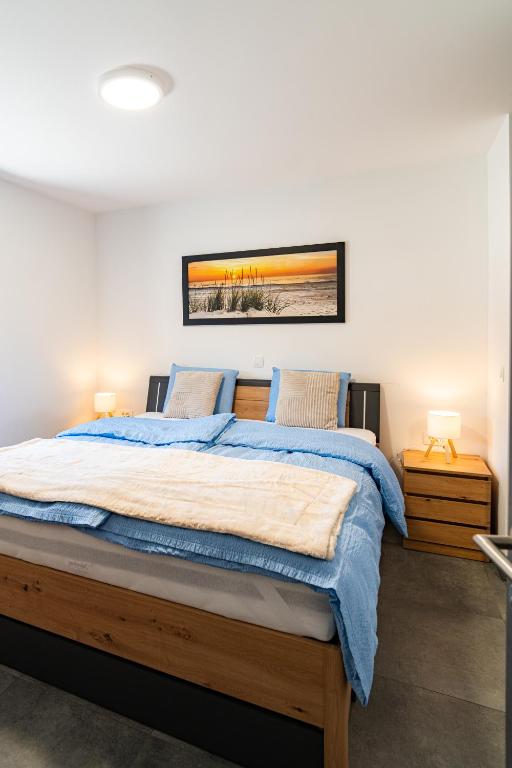 a bedroom with a large wooden bed with blue sheets at Vila Trta in Moravske-Toplice