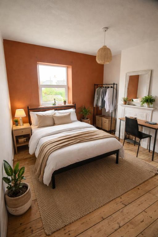 a bedroom with a large bed and a desk at Cosy double room close to coastal path routes in Barnstaple