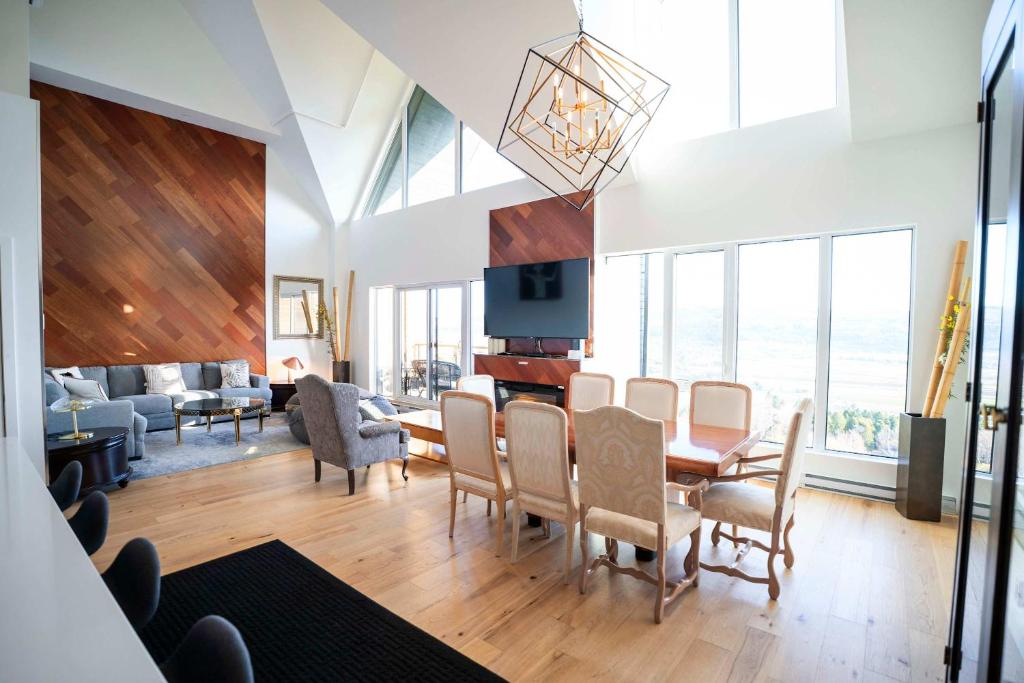 a living room with a table and chairs at 408 - Modern Condo - Pool & Panoramic View in Baie-Saint-Paul