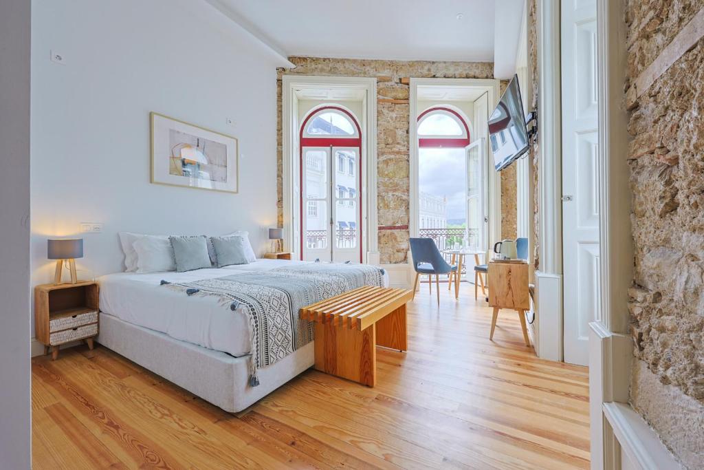 a bedroom with a bed and a table and chairs at Casa da Portagem by PURUS in Coimbra