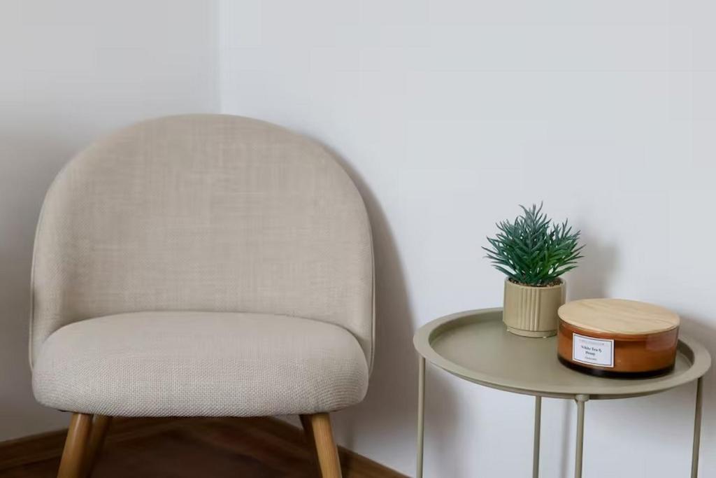 a white chair next to a table with a plant at Dottygal Fiumei UIA in Balatonboglár