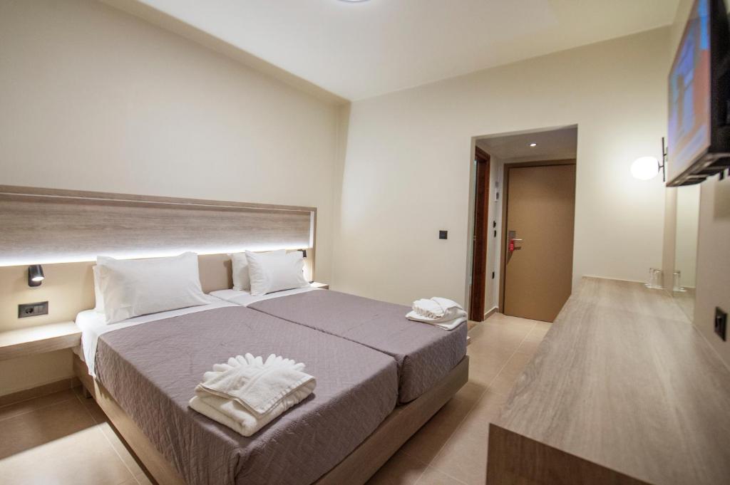 a bedroom with a large bed with two towels on it at Falassarna Hotel in Chania