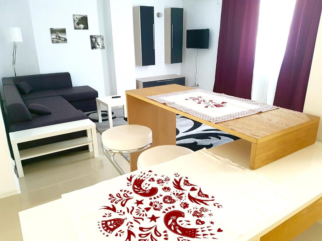 uma sala de estar com uma mesa e um sofá em Apartament Fundeni em Bucareste