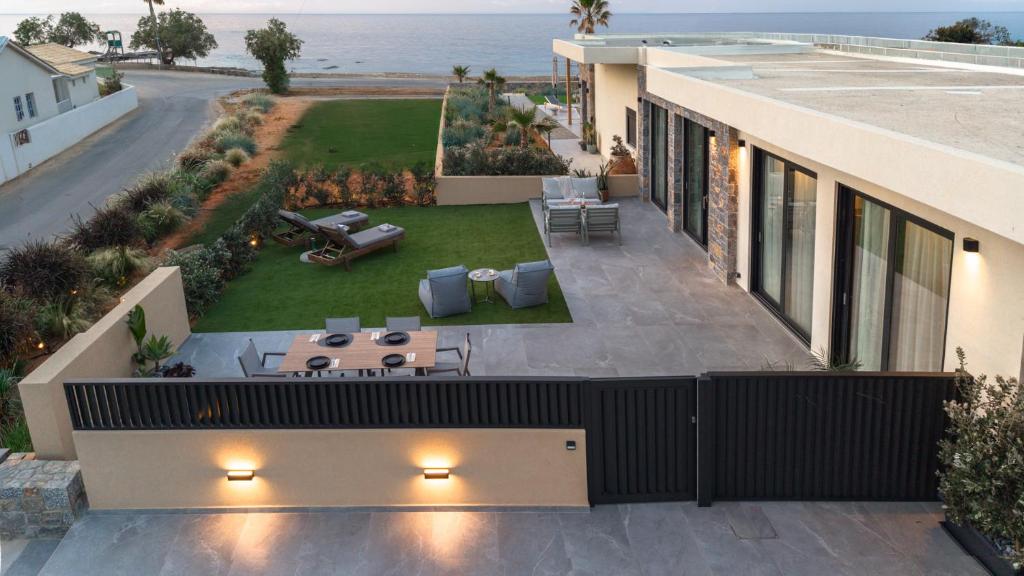 an aerial view of a house with a patio and the ocean at NAEMA Seafront Living 2BR Suite in Anissaras