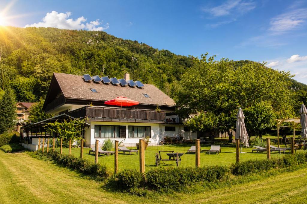 a house with a mountain in the background at Rooms Malina I Peaceful Stay Near Bled & Mountain Views in Blejska Dobrava