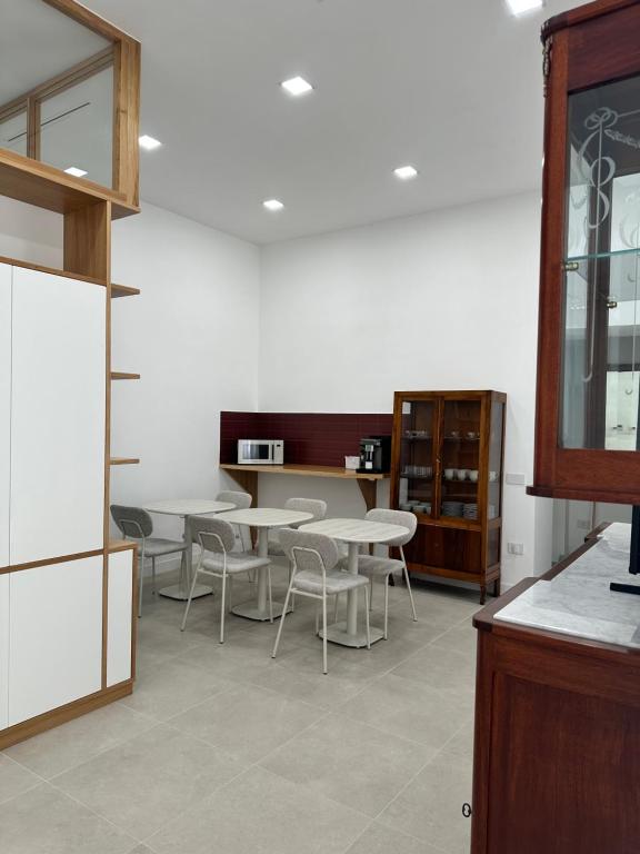 a room with tables and chairs and a kitchen at I Colori della Bellezza in Gragnano