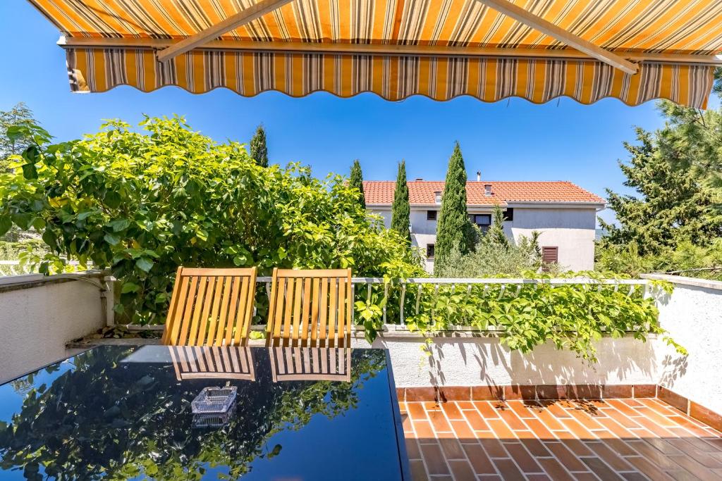 two chairs sitting on a patio with a pool at Punta Debij Select Apartments in Punat