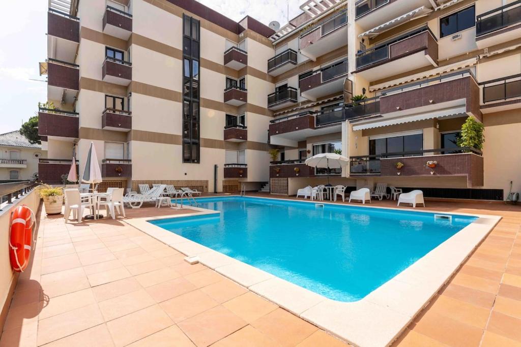a swimming pool in front of a building at Estoril Riviera Residences in Estoril