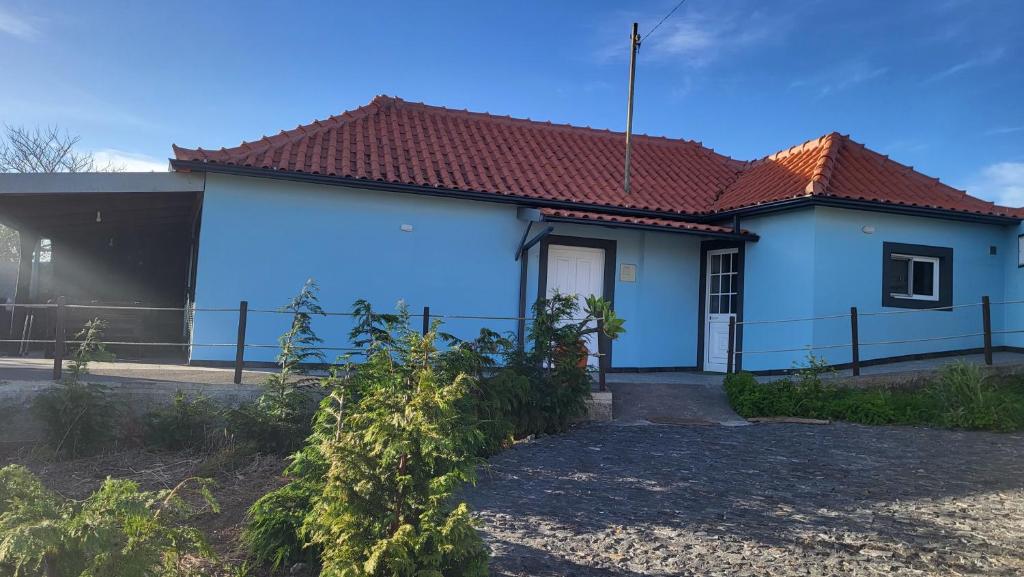 a blue house with a red roof at Casa de Campo Serrão in Calheta