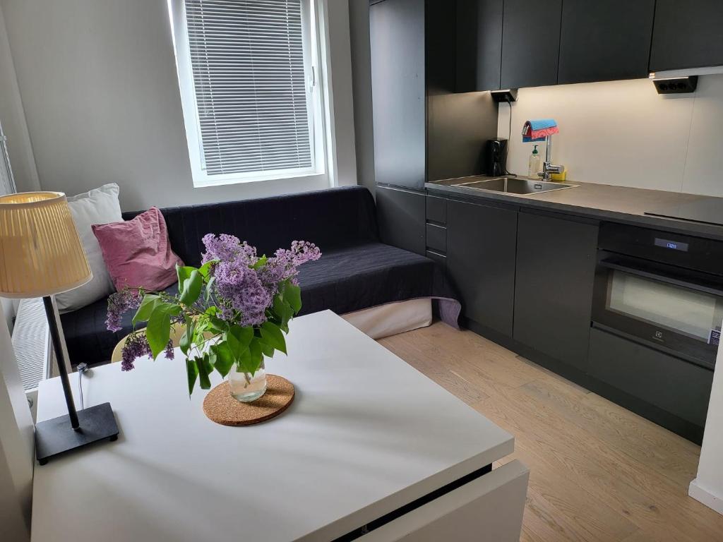 a living room with a couch and a table with flowers on it at Studio Sleeps 2 Sollentuna centre in Sollentuna