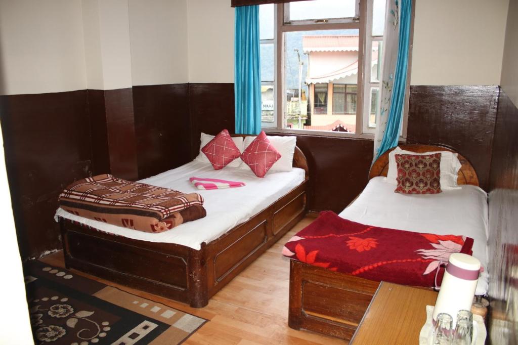 a room with two beds and a window at Hotel reegyal in Ravangla