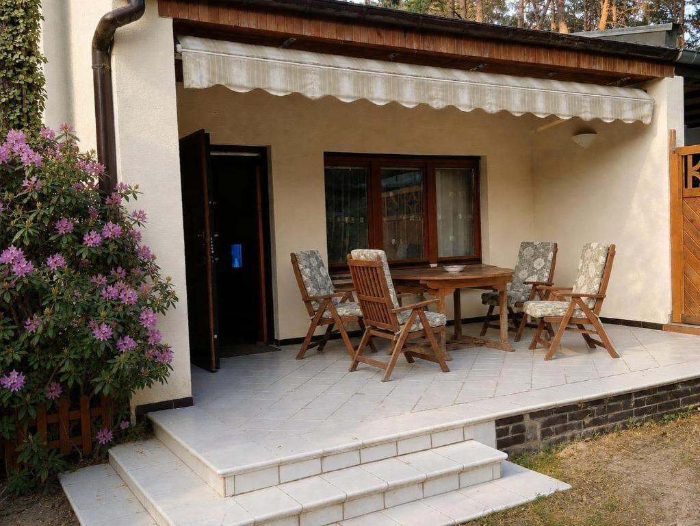 a patio with chairs and a table in front of a house at Domek nad jeziorem Mierzyńskim 50m2 in Mierzyn