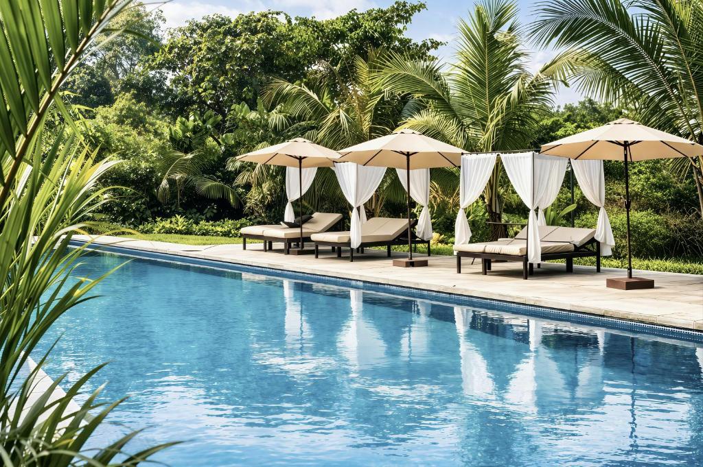 a swimming pool with chairs and umbrellas next to a pool at Hidden Valley Eco Retreat Trang An in Ninh Binh