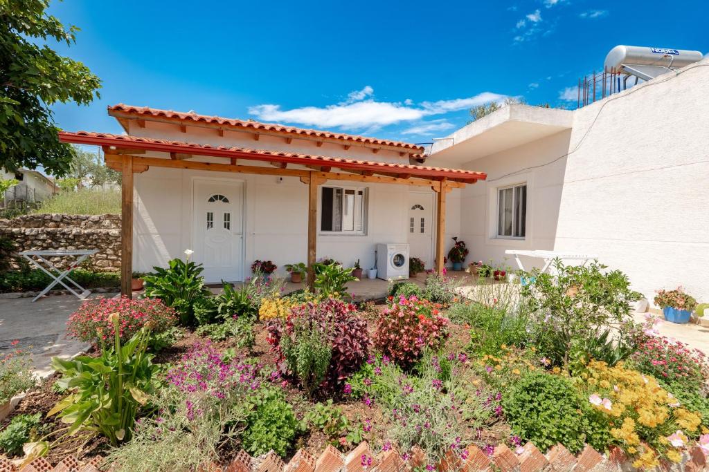 a house with a garden in front of it at Nino's rooms in Ksamil