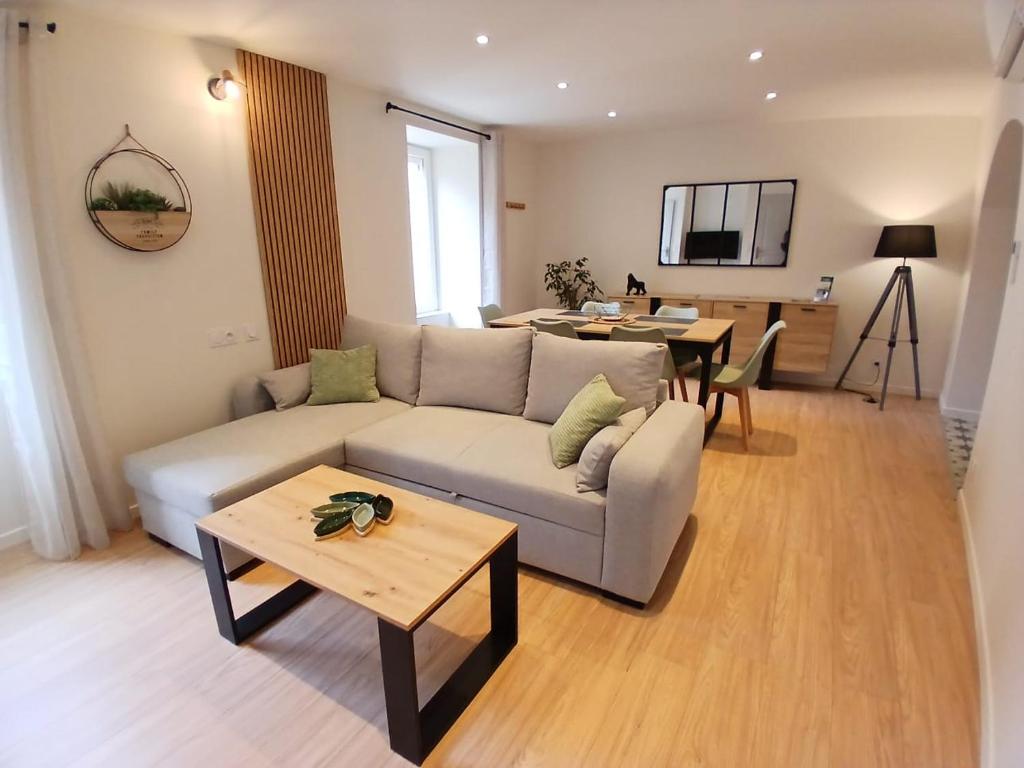 a living room with a couch and a table at La maisonnette in Saint-Georges-de-Luzençon