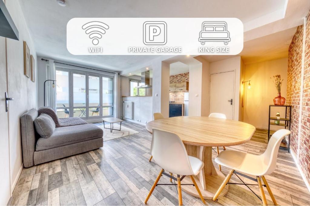 a living room with a table and a couch at Le petit nid Rémois - Parking - King size in Reims
