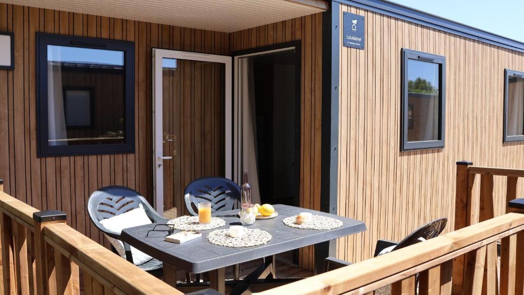 a table and chairs on the deck of a house at Camping Tikayan Beau Séjour in Le Lavandou