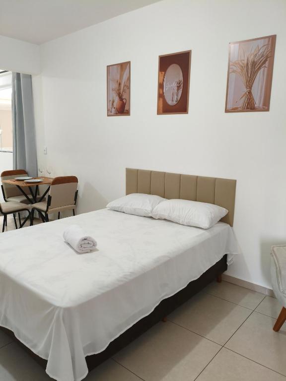 a bedroom with a bed and a table and chairs at Próximo a UFV 950m, prédio muito tranquilo in Viçosa