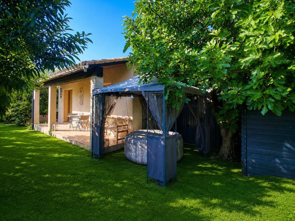 a house with a blue canopy in a yard at Chambre d'hôte Amouratcha in Fabrègues