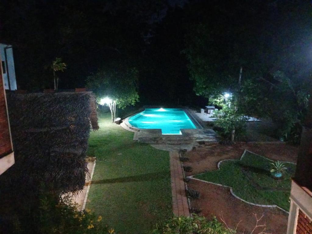 a backyard at night with a swimming pool at Vallee 69 Eco Villa-Tissa,Yala in Tissamaharama