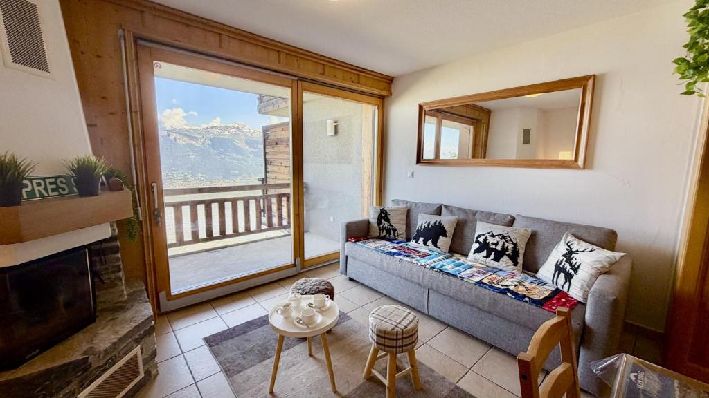 a living room with a couch and a large window at Plein Ciel VA 022 - MOUNTAIN apartment 4 pers in Veysonnaz