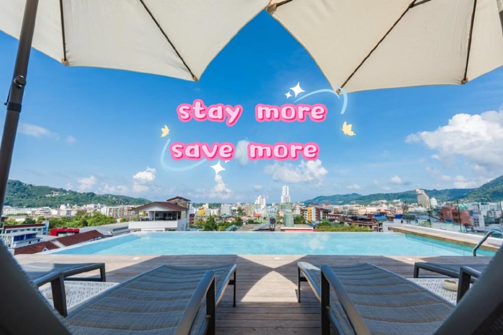 a swimming pool with umbrellas and a sign that says stay more save more at LullaBella Hotel Patong,Nanai Road in Patong Beach