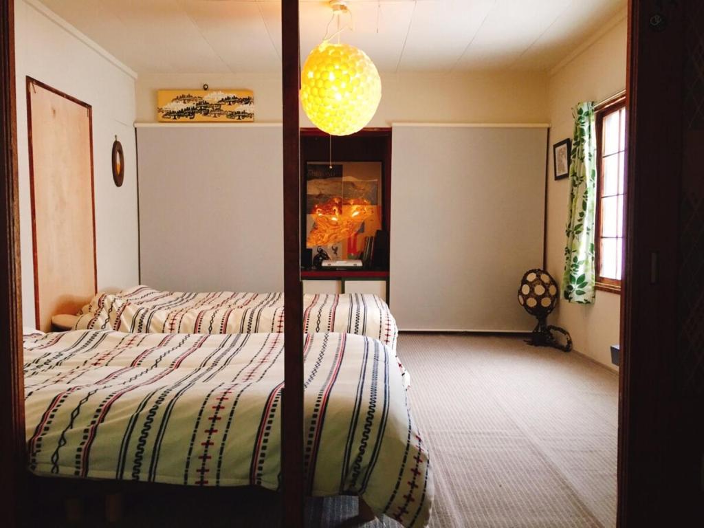 a bedroom with a bed and a chandelier at MEGANE HOUSE First floor All private in Rankoshi