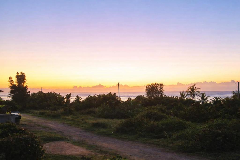 a dirt road with the sunset in the background at Chill-Ax Cottages in Port Shepstone