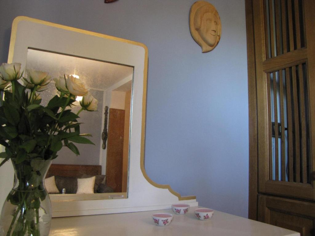 un vaso con fiori su un tavolo di fronte a uno specchio di A casa della zia a Farra di Soligo
