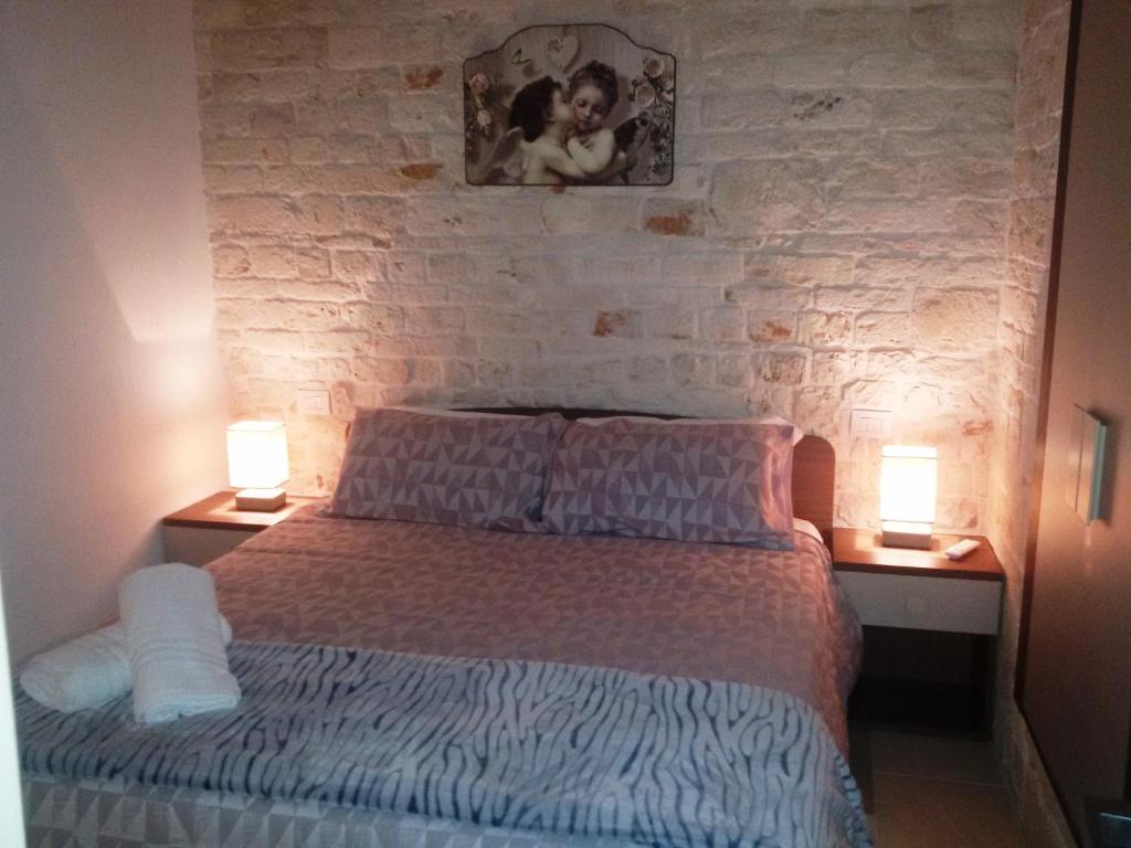1 dormitorio con 1 cama con 2 lámparas en 2 mesas en Dimore Vino&Amore en Alberobello