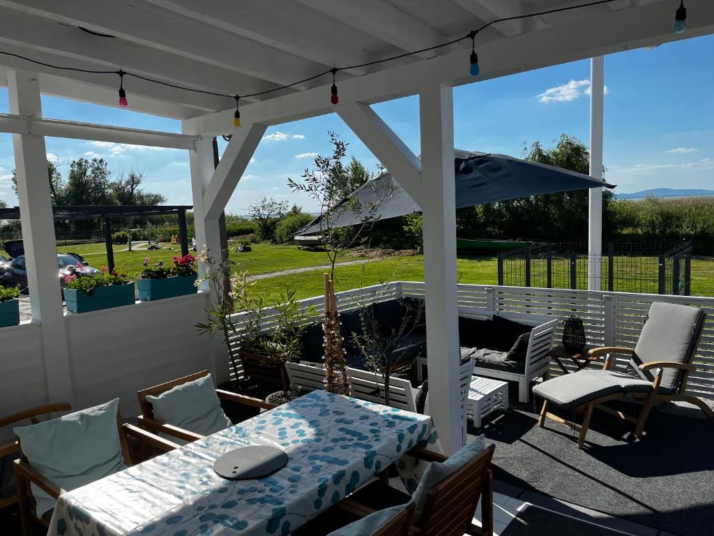 a patio with a table and chairs and an umbrella at Fenyves Bay Apartman in Balatonfenyves