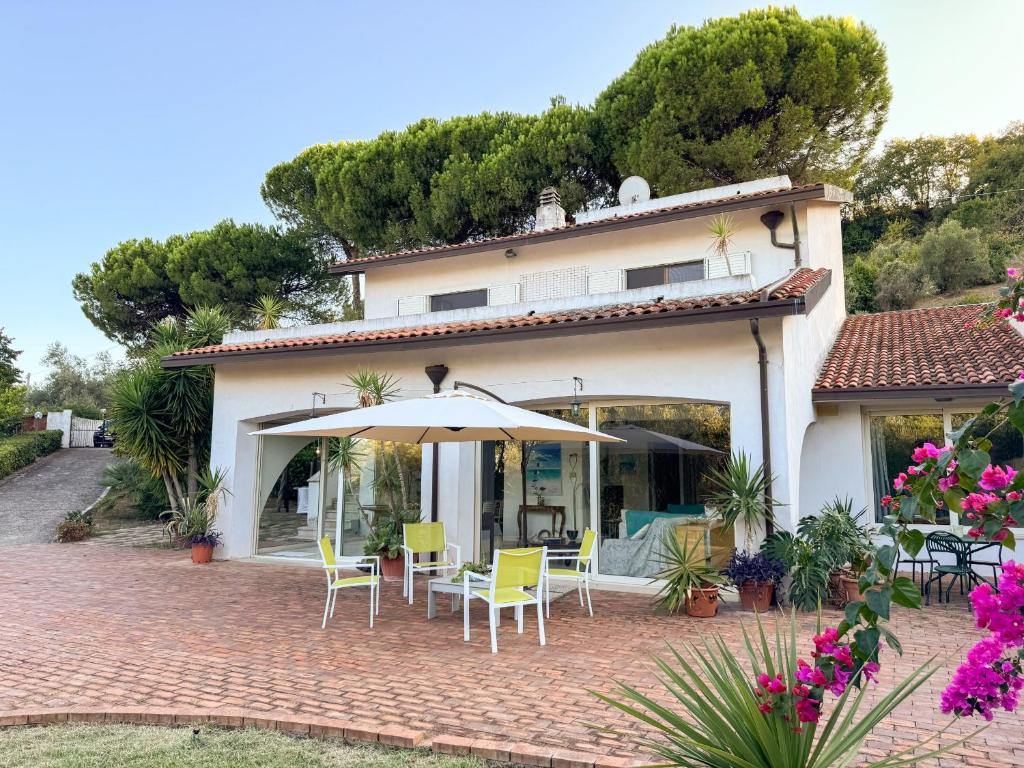 a house with a patio with chairs and an umbrella at Approdo in Ortona