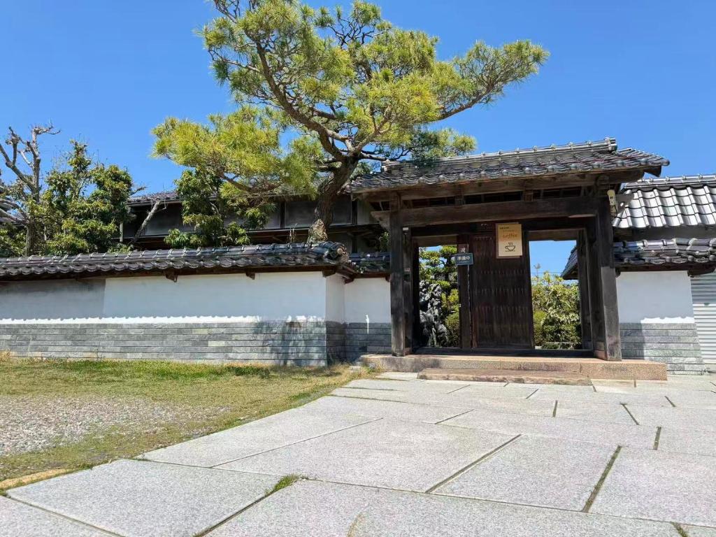 a gate to a building with a tree in the background at 結良house in Yura