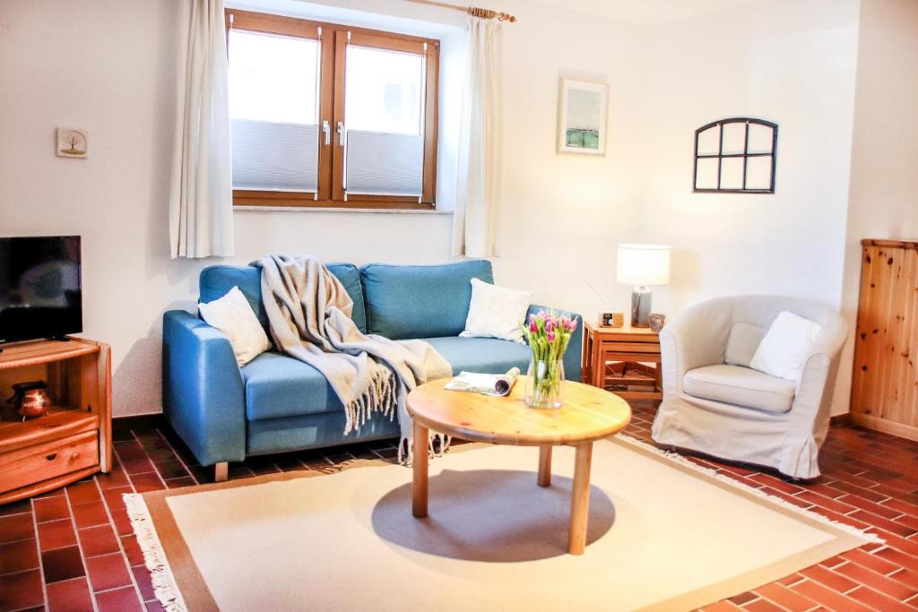 a living room with a blue couch and a table at FeWo Adele ruhige Auszeit am Dümmersee in Hüde