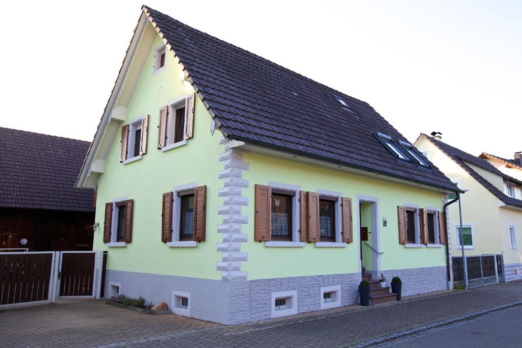 a yellow and white house with a black roof at apartment fewo efosa in Kappel-Grafenhausen