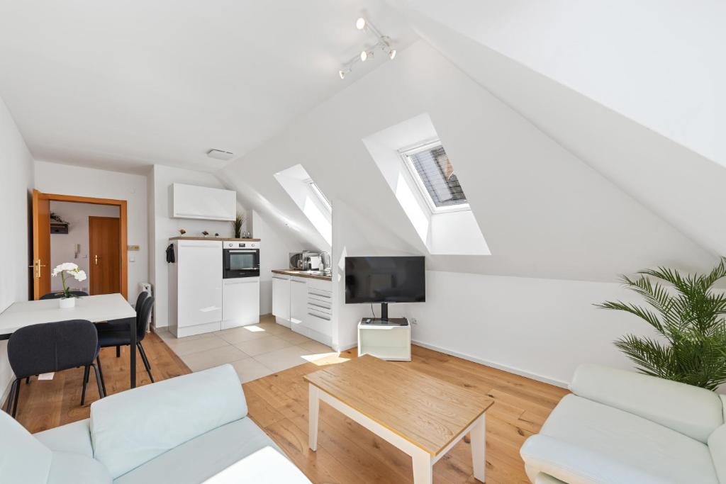 a living room with white furniture and a table at Stiftblick Residence Melk in Melk